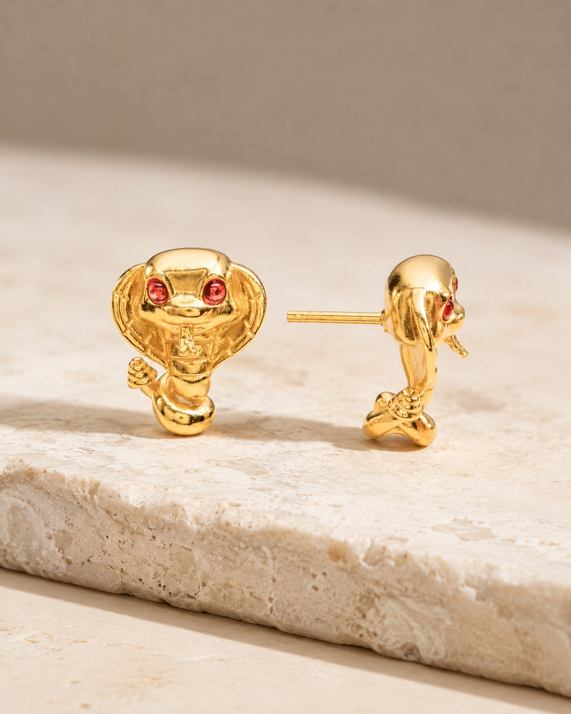 CARV. gold cobra stud earrings with red stone eyes and sculpted snake motif product display
