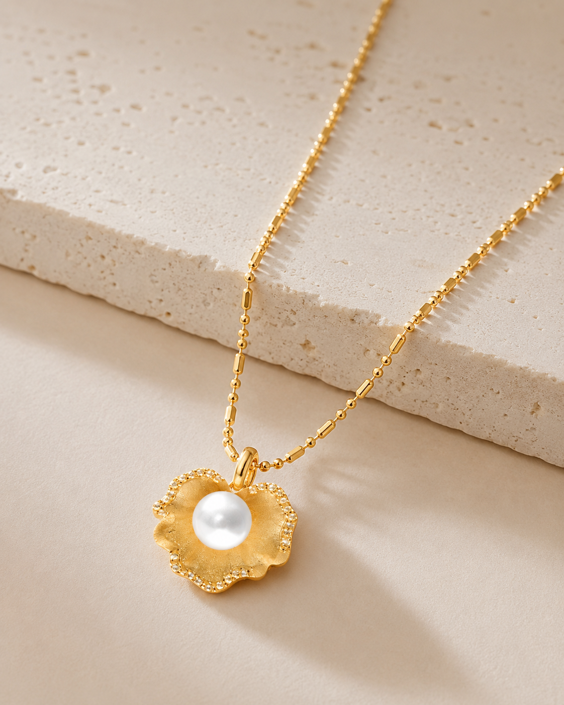 CARV. gold pearl flower pendant necklace with round pearl centre, textured petals and fine chain detail