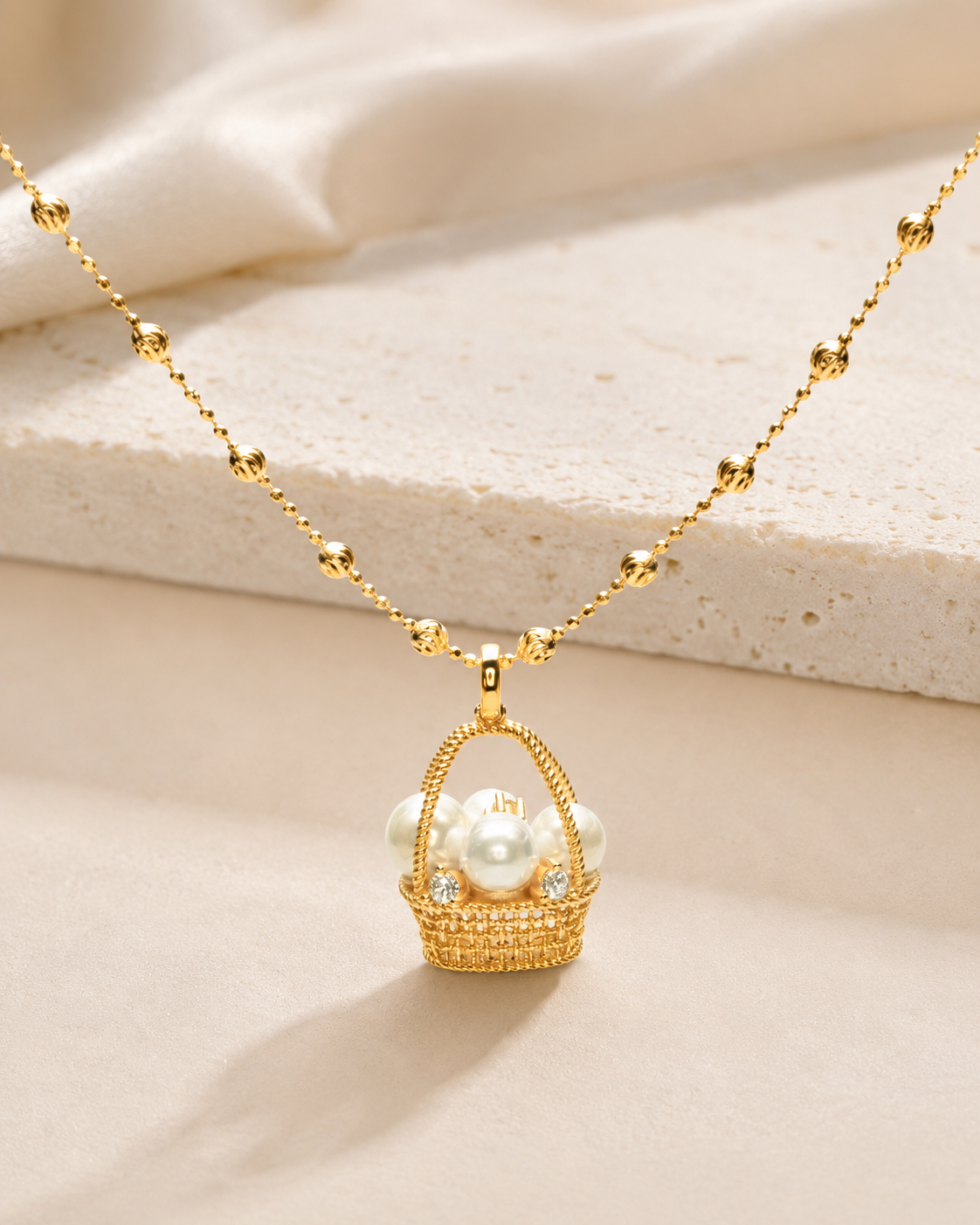 CARV. gold pearl basket necklace with pearl basket pendant, crystal accents and beaded chain displayed flat lay
