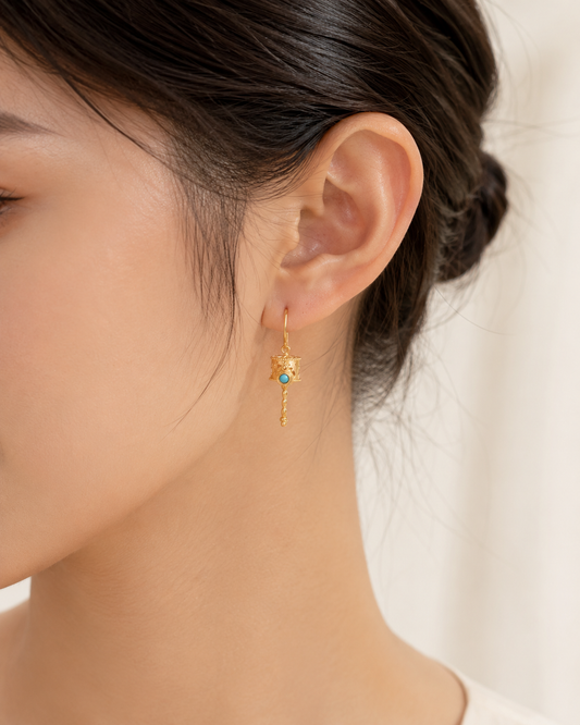 CARV. gold lantern drop earrings with turquoise detail worn on ear