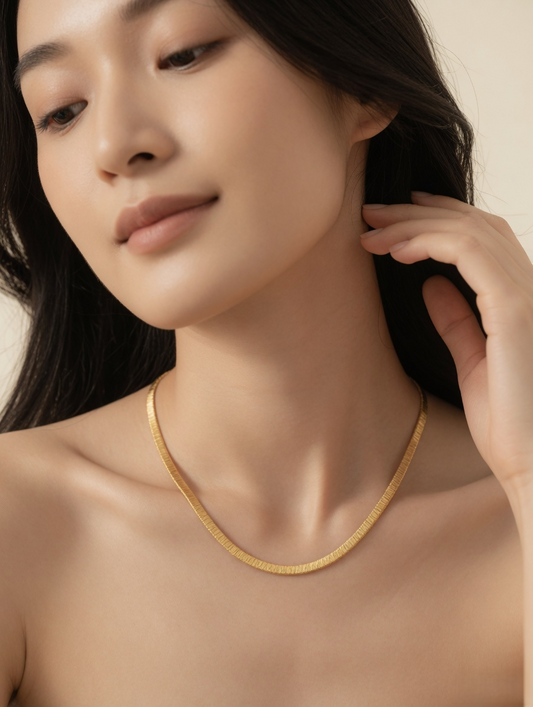 CARV. gold textured collar necklace worn at collarbone with smooth curved chain shape