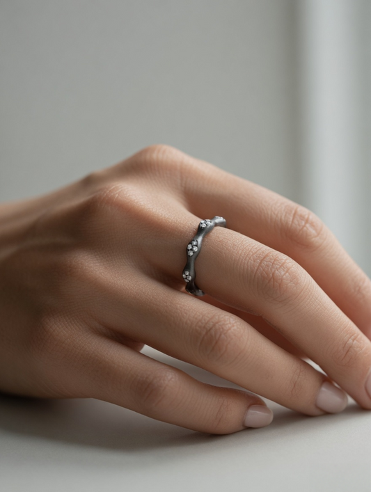 CARV. black flower ring worn on hand with irregular petal band and crystal accents