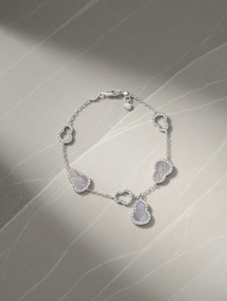 CARV. silver gourd charm bracelet with pink stone details and halo-set drop charm product display