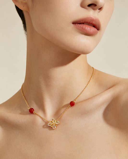 CARV. gold red agate knot necklace worn at collarbone with red bead stations and knot pendant