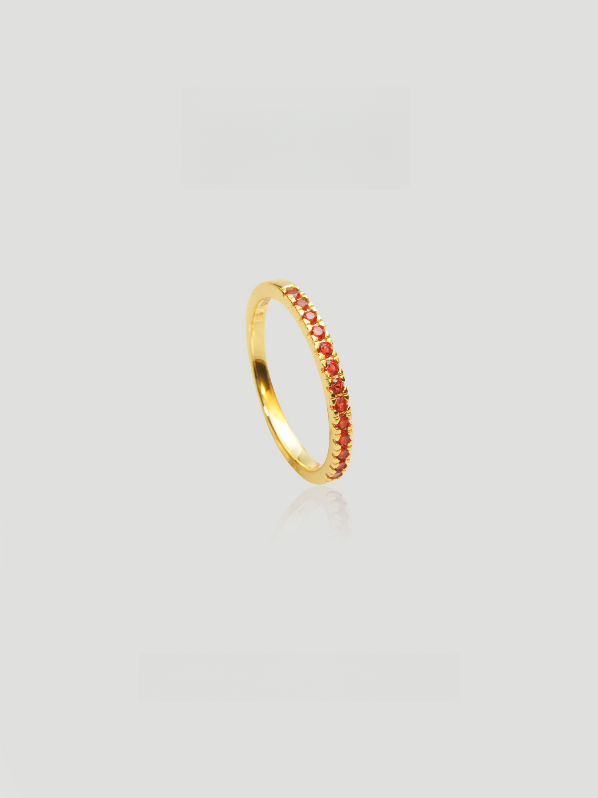 CARV. gold red stone band ring with slim polished band and fine red stone detail