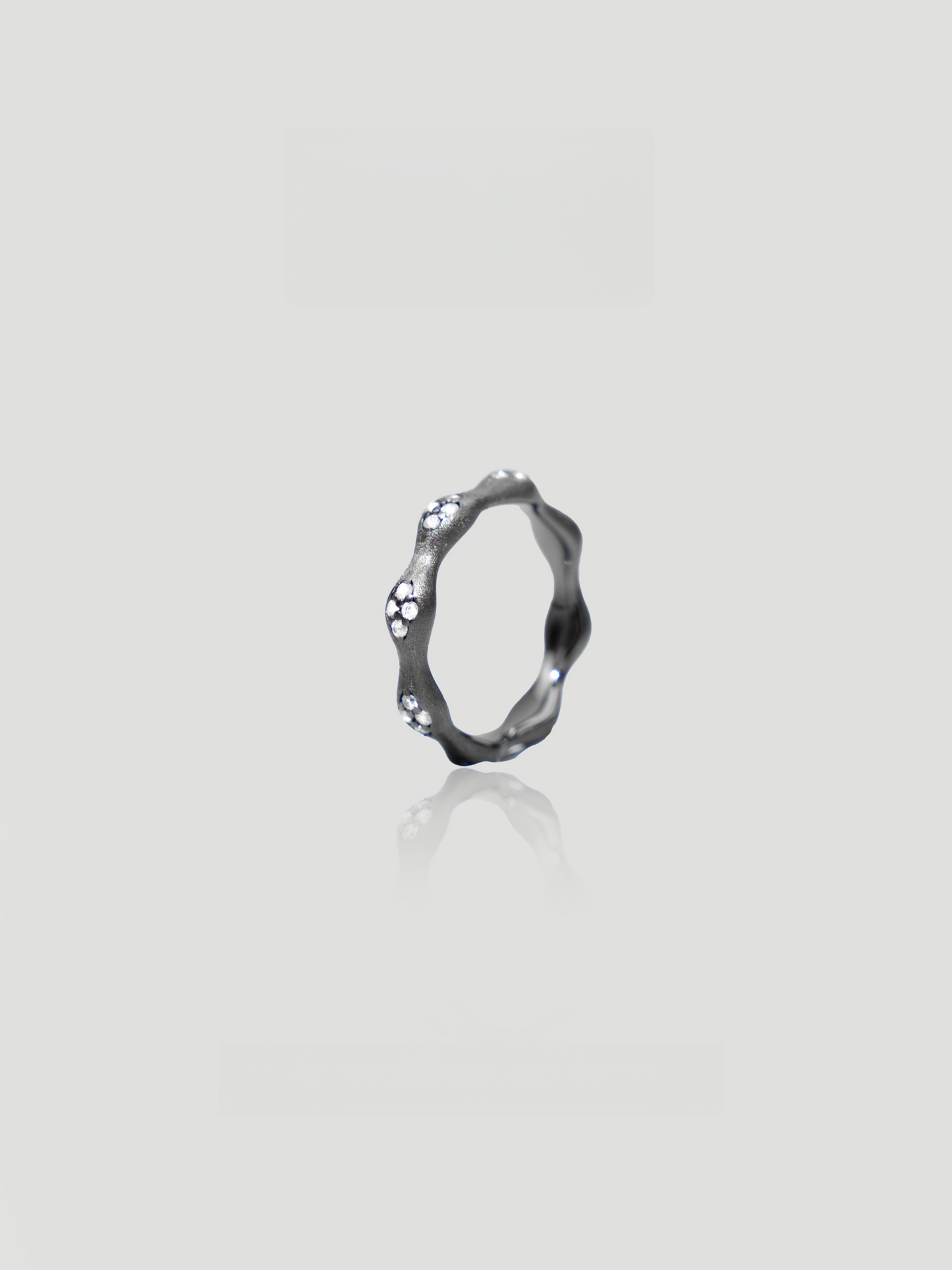 CARV. black flower ring with irregular petal band, crystal accents and dark metal finish