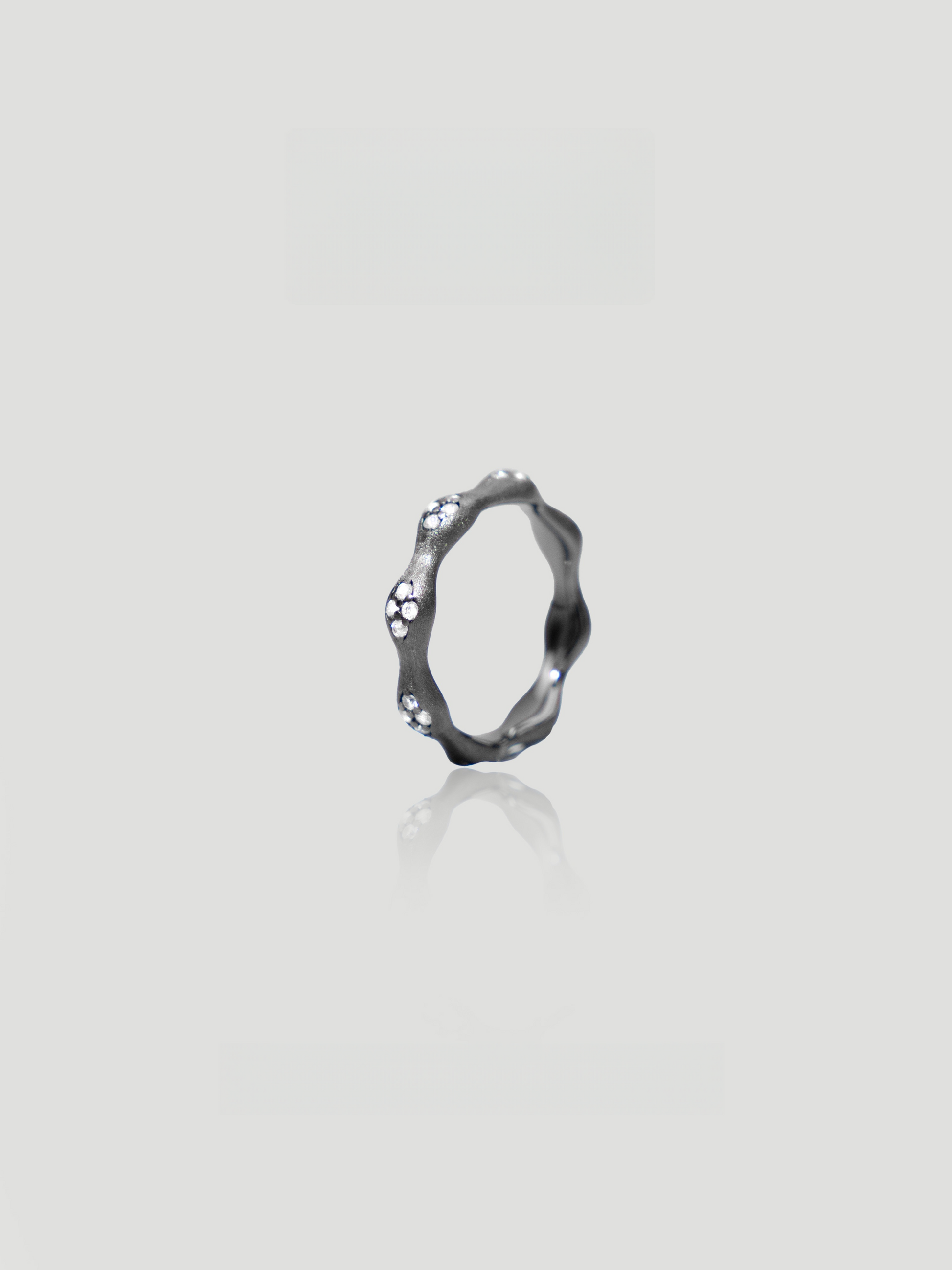 CARV. black flower ring with irregular petal band, crystal accents and dark metal finish