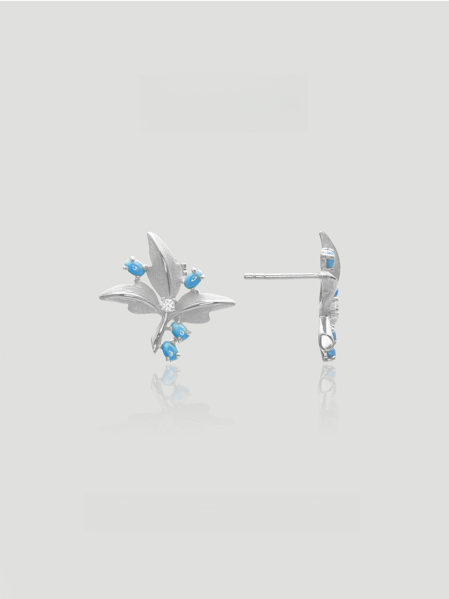 CARV. silver turquoise floral stud earrings with blue stone accents and crystal center, front and side view