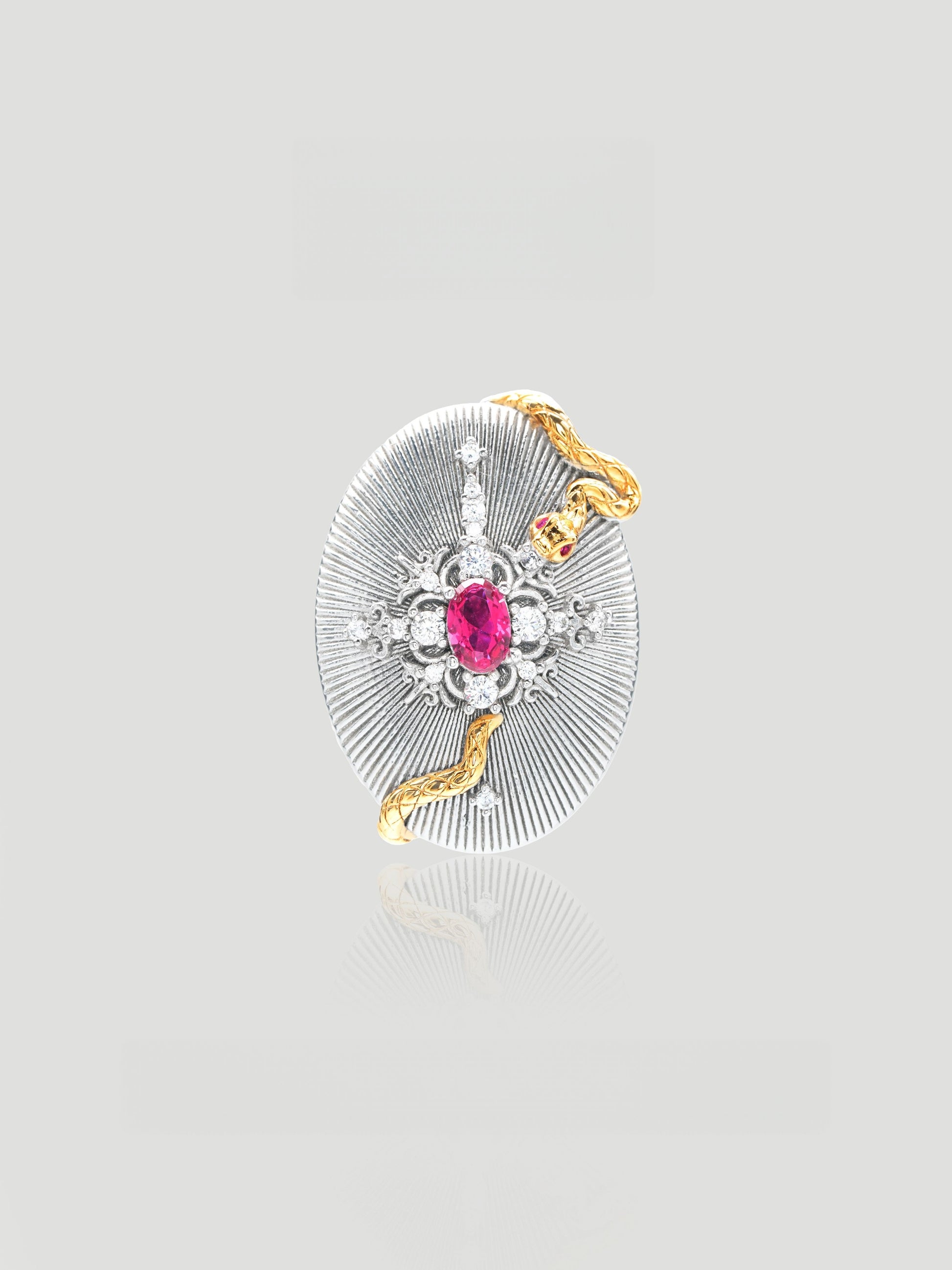 CARV. ruby serpent medallion pendant necklace with oval silver medallion, gold snake detail and pink centre stone