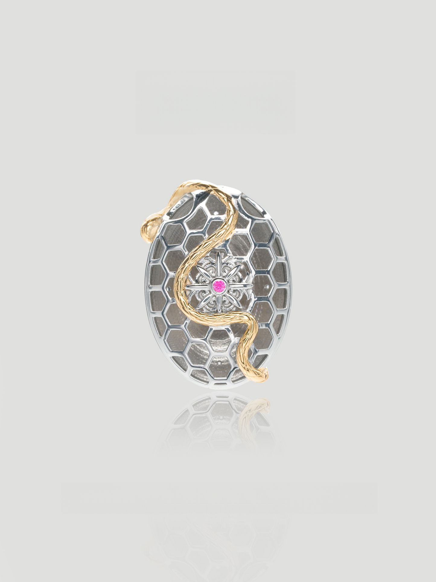 CARV. ruby serpent medallion pendant with oval silver medallion, gold snake detail and pink centre stone