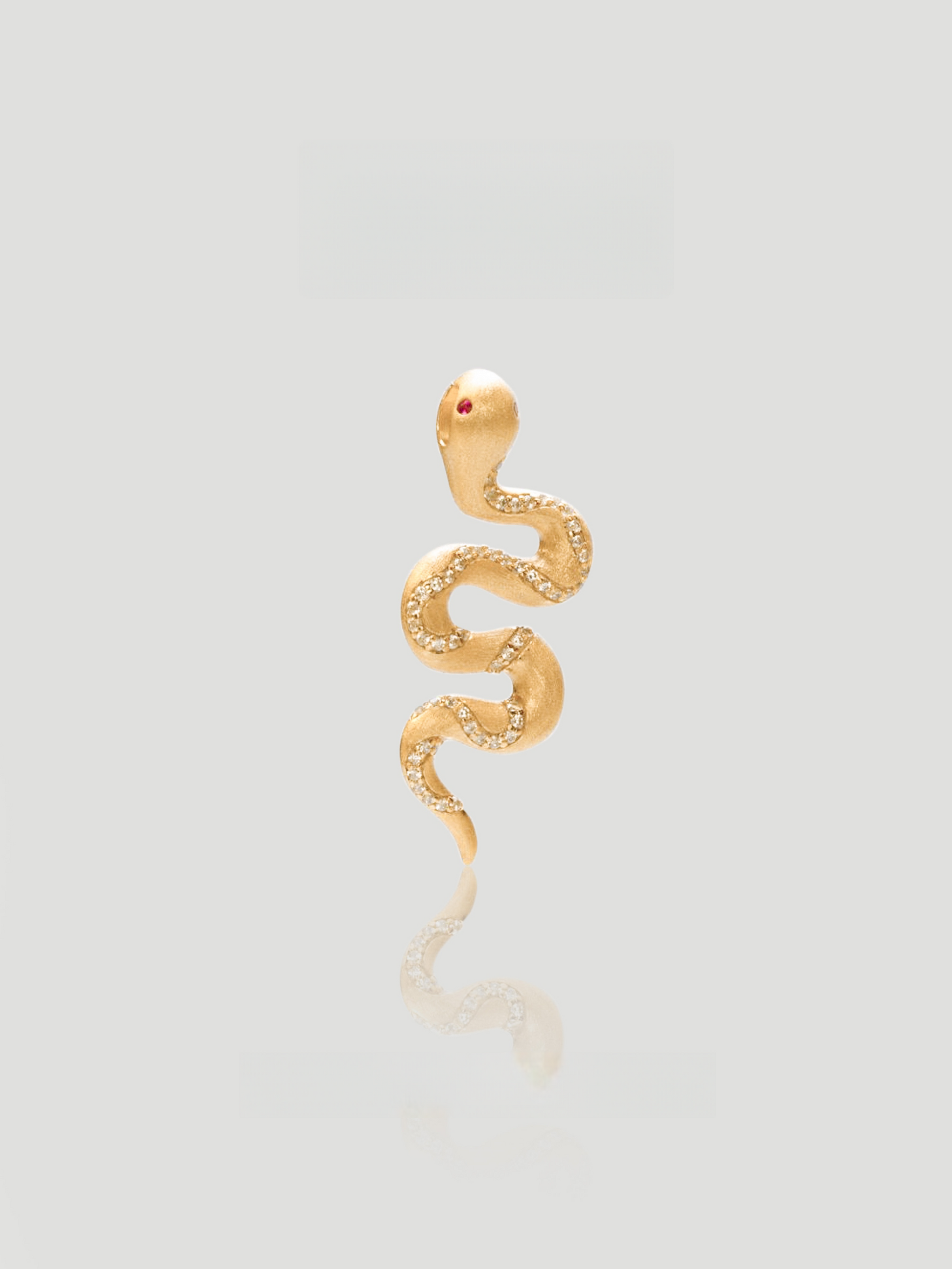 CARV. gold snake pendant necklace with textured serpent charm, fine chain and red eye detail