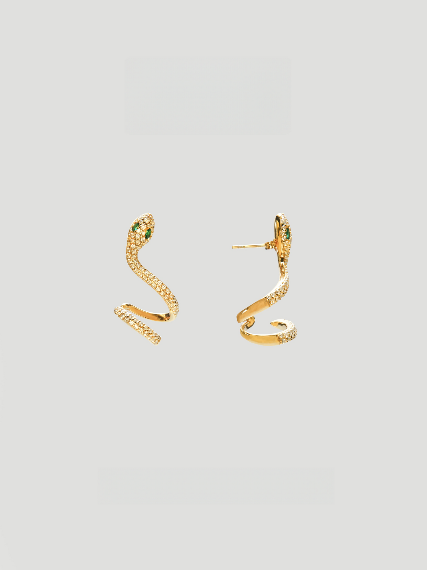CARV. gold snake curve earrings with pavé texture, sculptural serpent shape and green eye detail