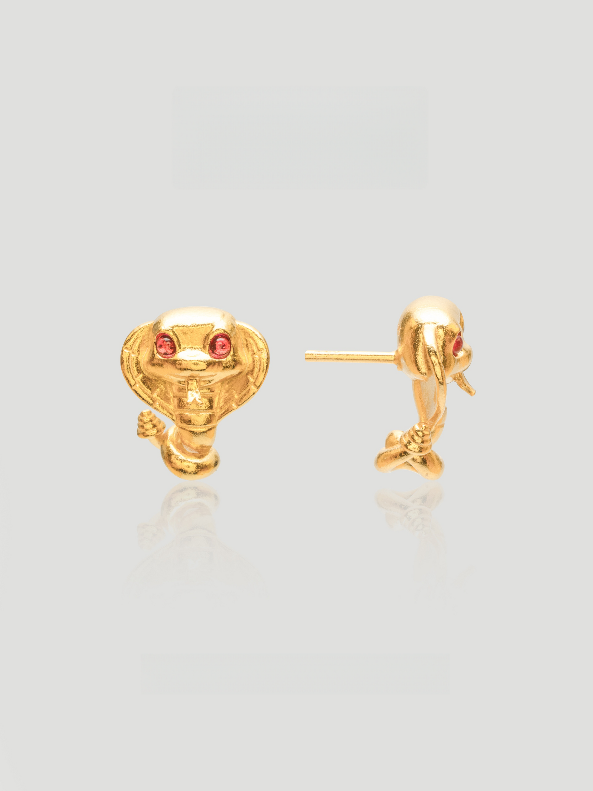 CARV. gold cobra stud earrings with red stone eyes and sculpted snake head detail product close-up