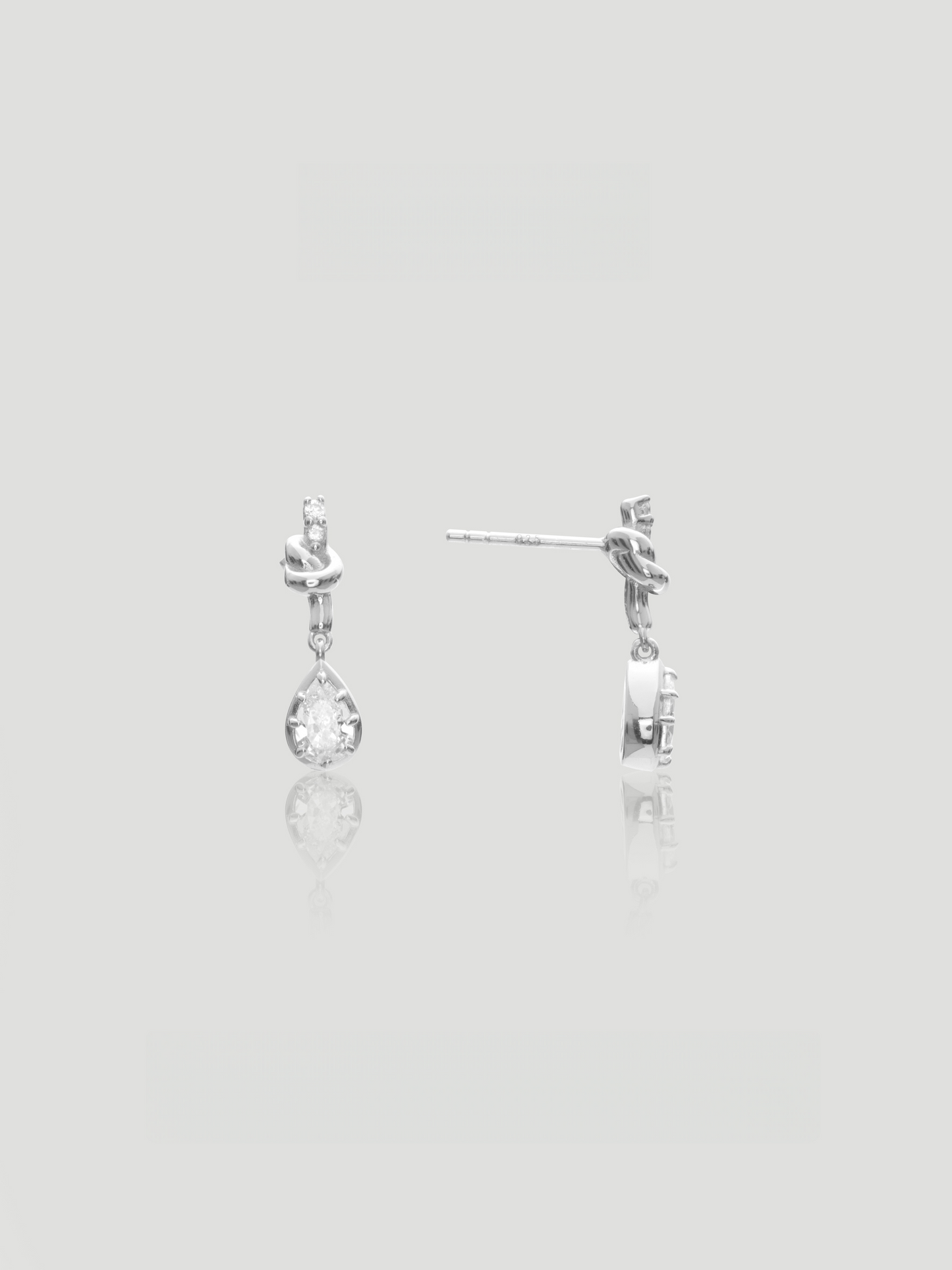 CARV. silver bow knot drop earrings with pear-cut clear stones and delicate teardrop design