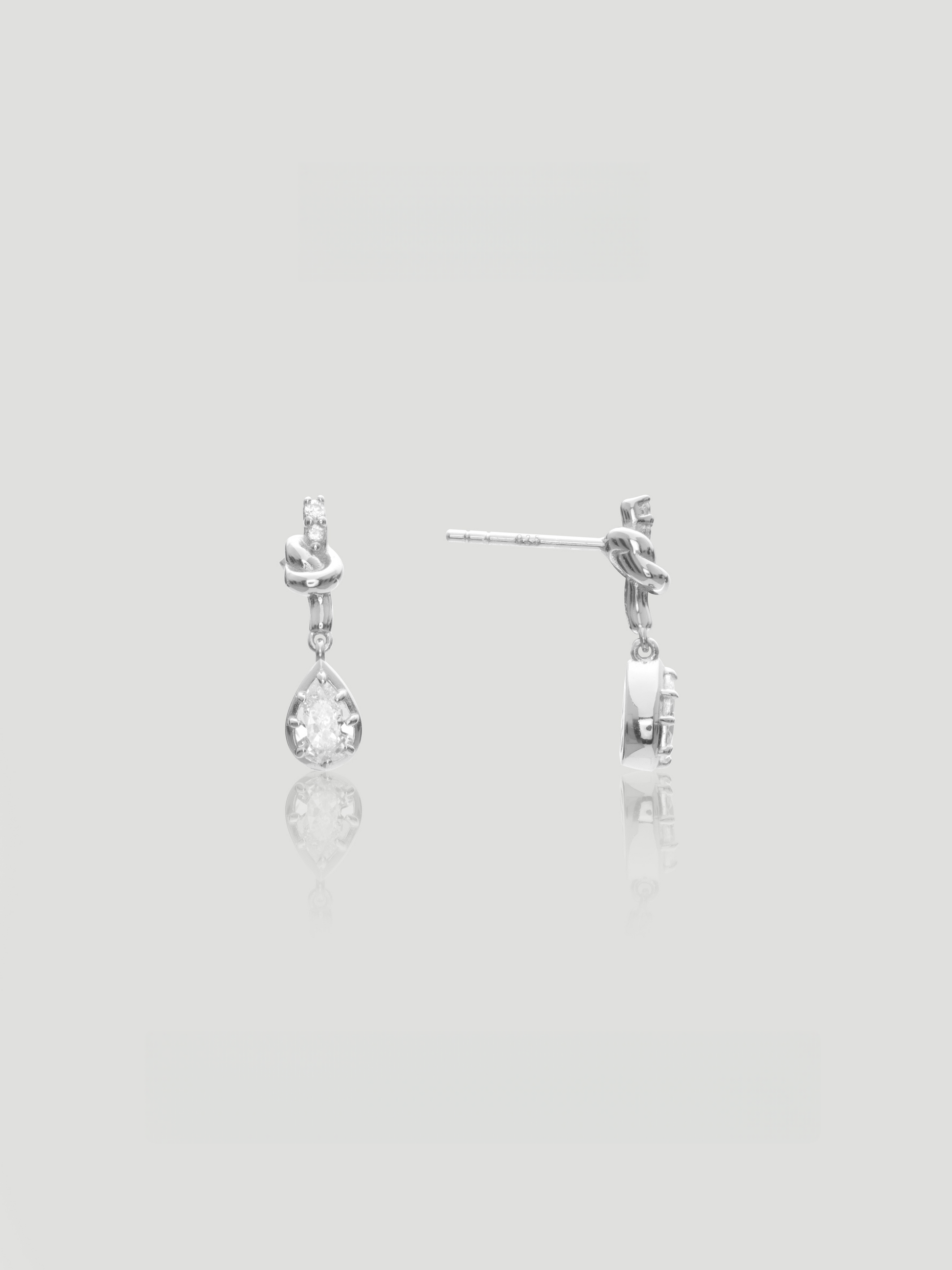 CARV. silver bow knot drop earrings with pear-cut clear stones and delicate teardrop design