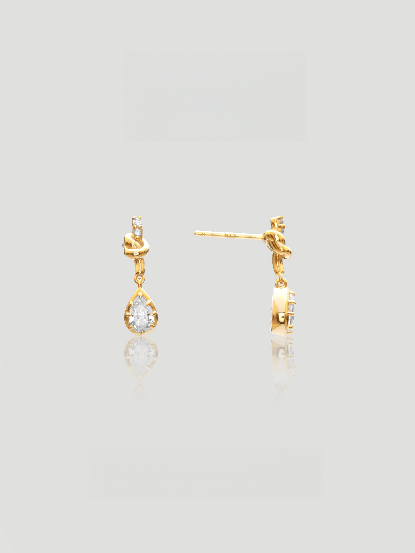 CARV. gold bow knot drop earrings with pear-cut clear stones and delicate teardrop design