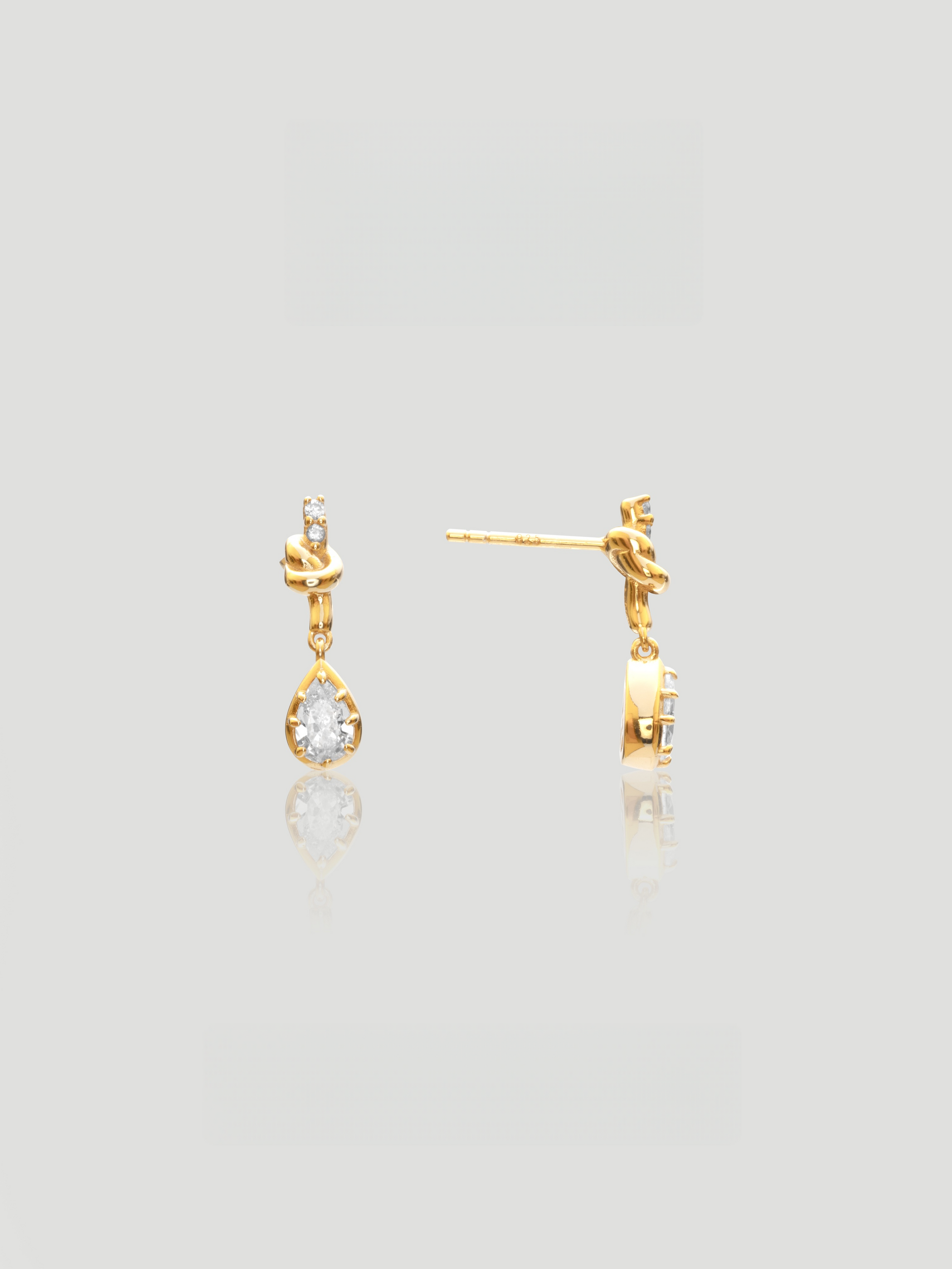 CARV. gold bow knot drop earrings with pear-cut clear stones and delicate teardrop design
