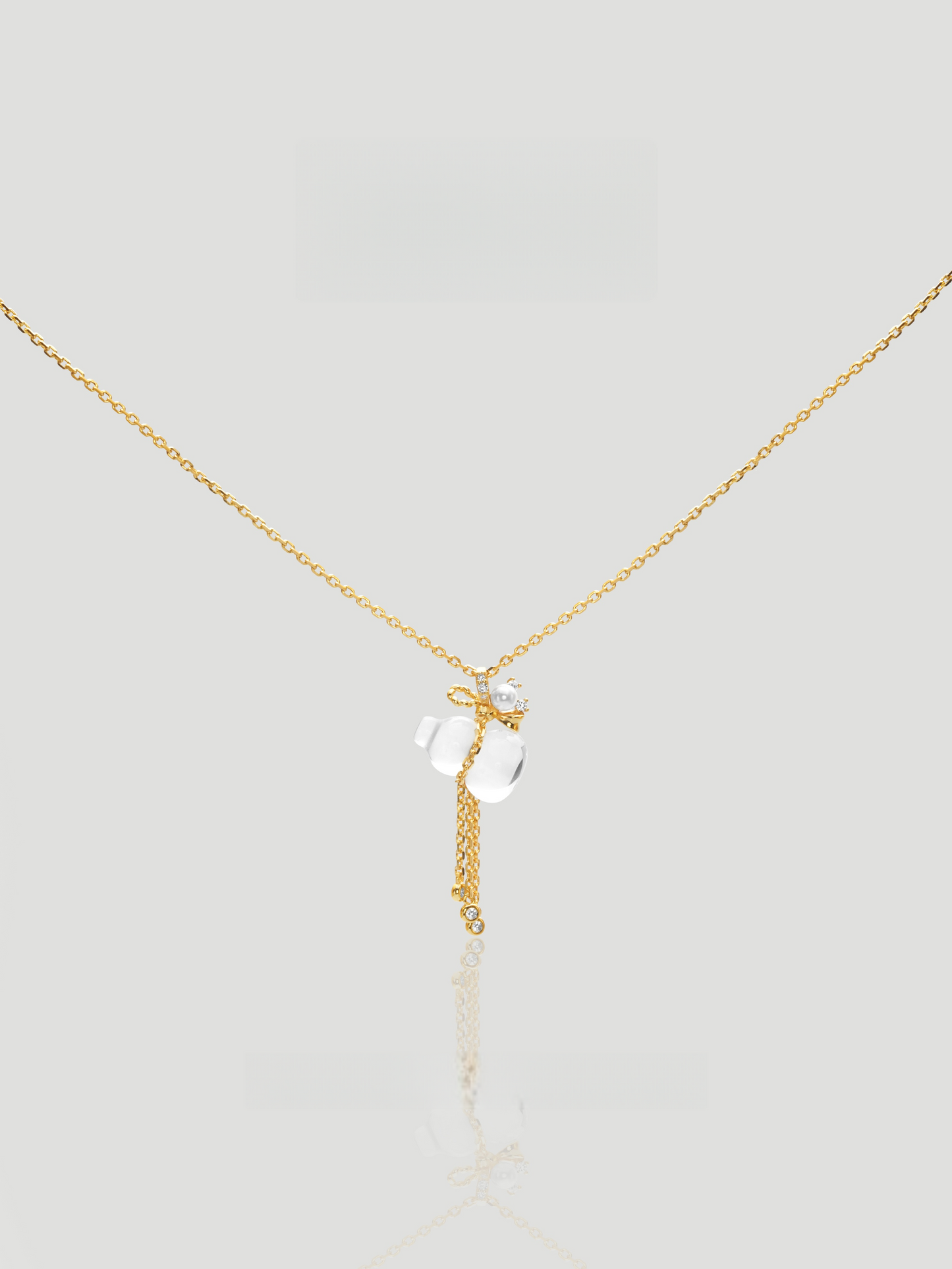 CARV. gold pendant necklace with white crystal charm, floral top detail and tassel drop product close-up
