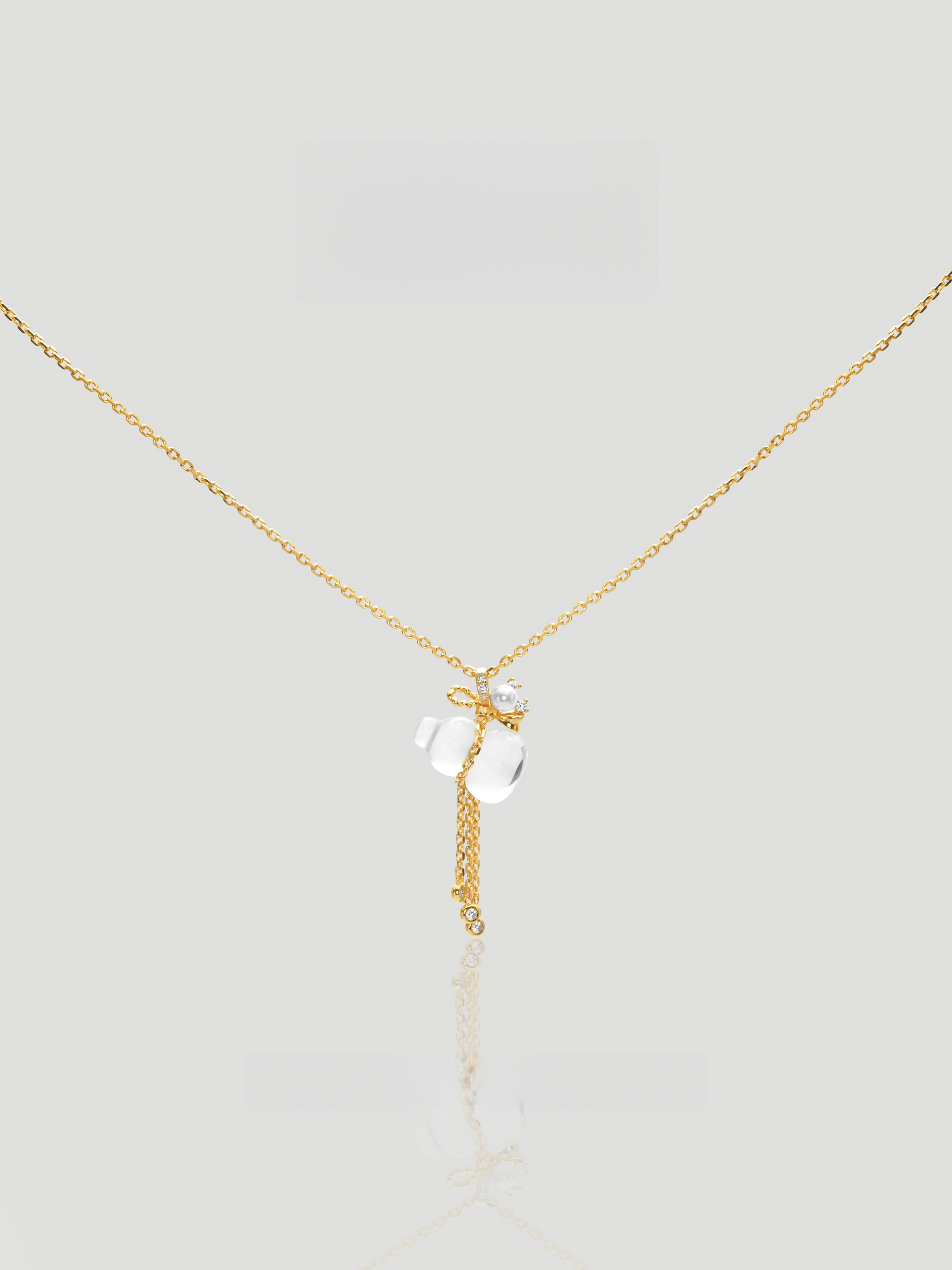 CARV. gold pendant necklace with white crystal charm, floral top detail and tassel drop product close-up