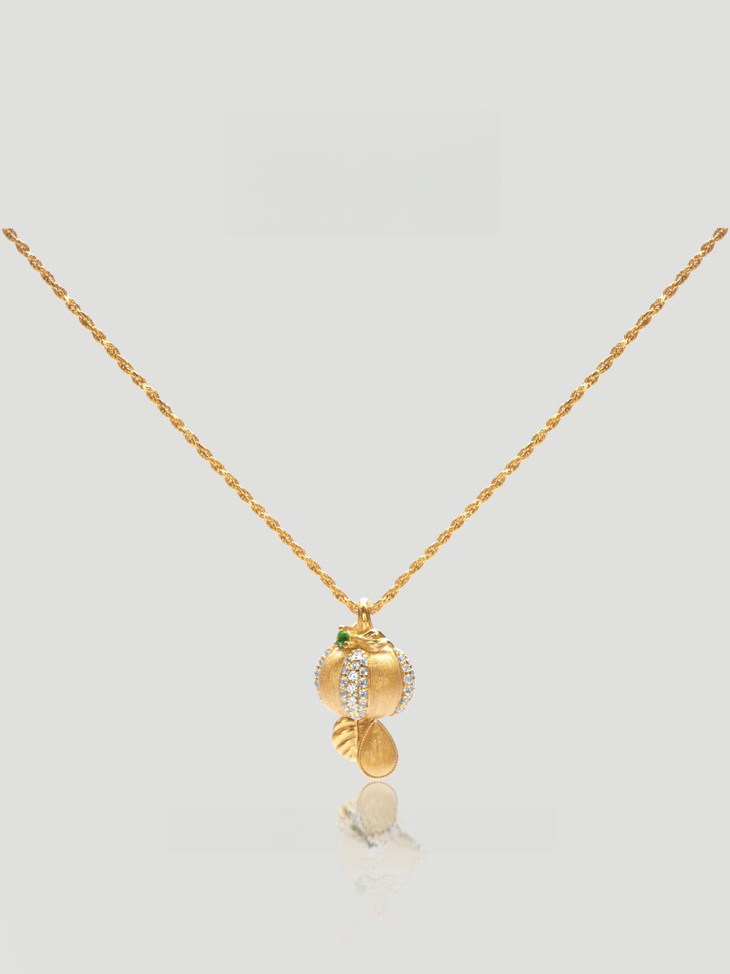 CARV. gold pumpkin pendant necklace with green stone accent and textured round drop charm product close-up