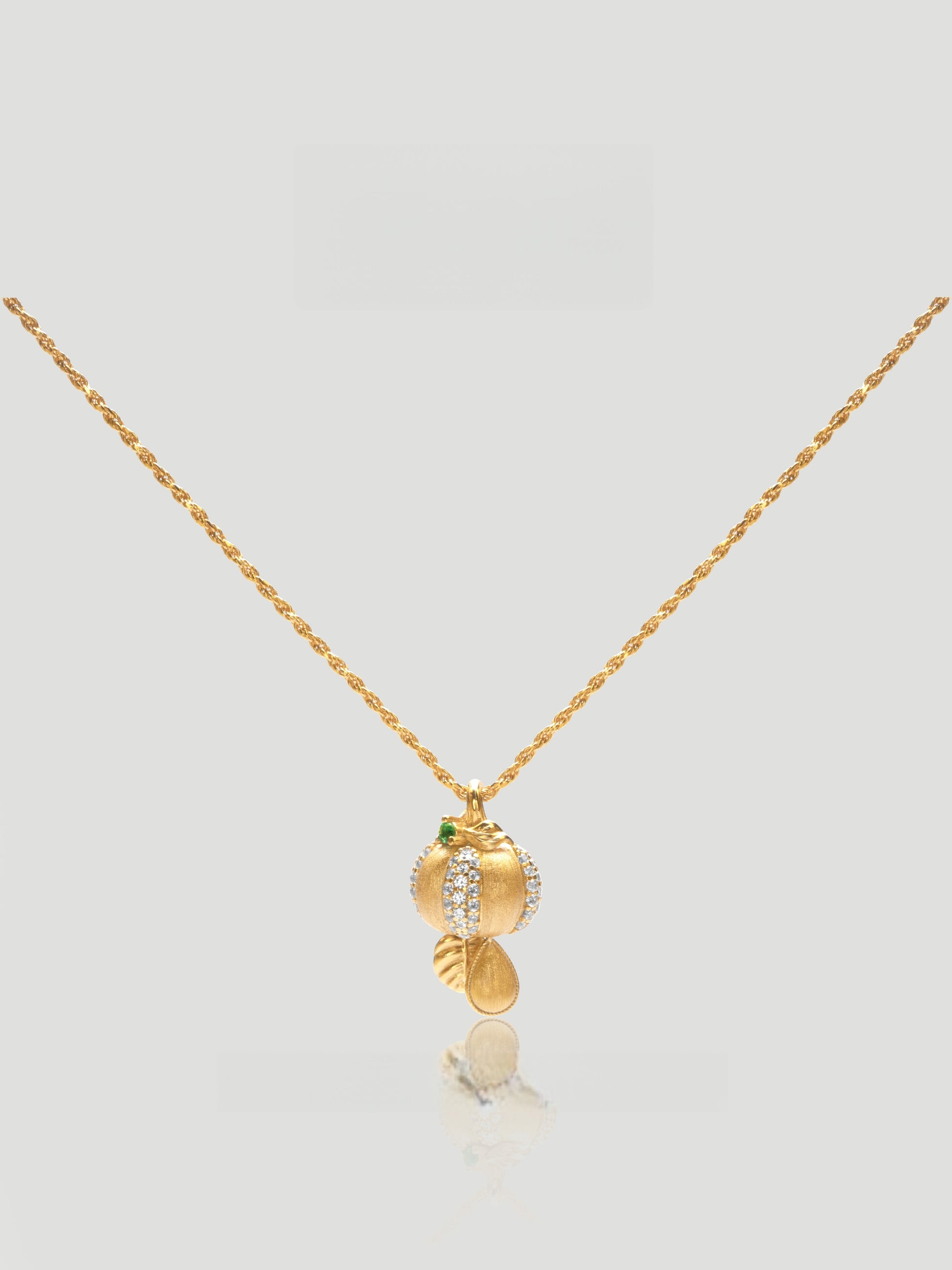 CARV. gold pumpkin pendant necklace with green stone accent and textured round drop charm product close-up