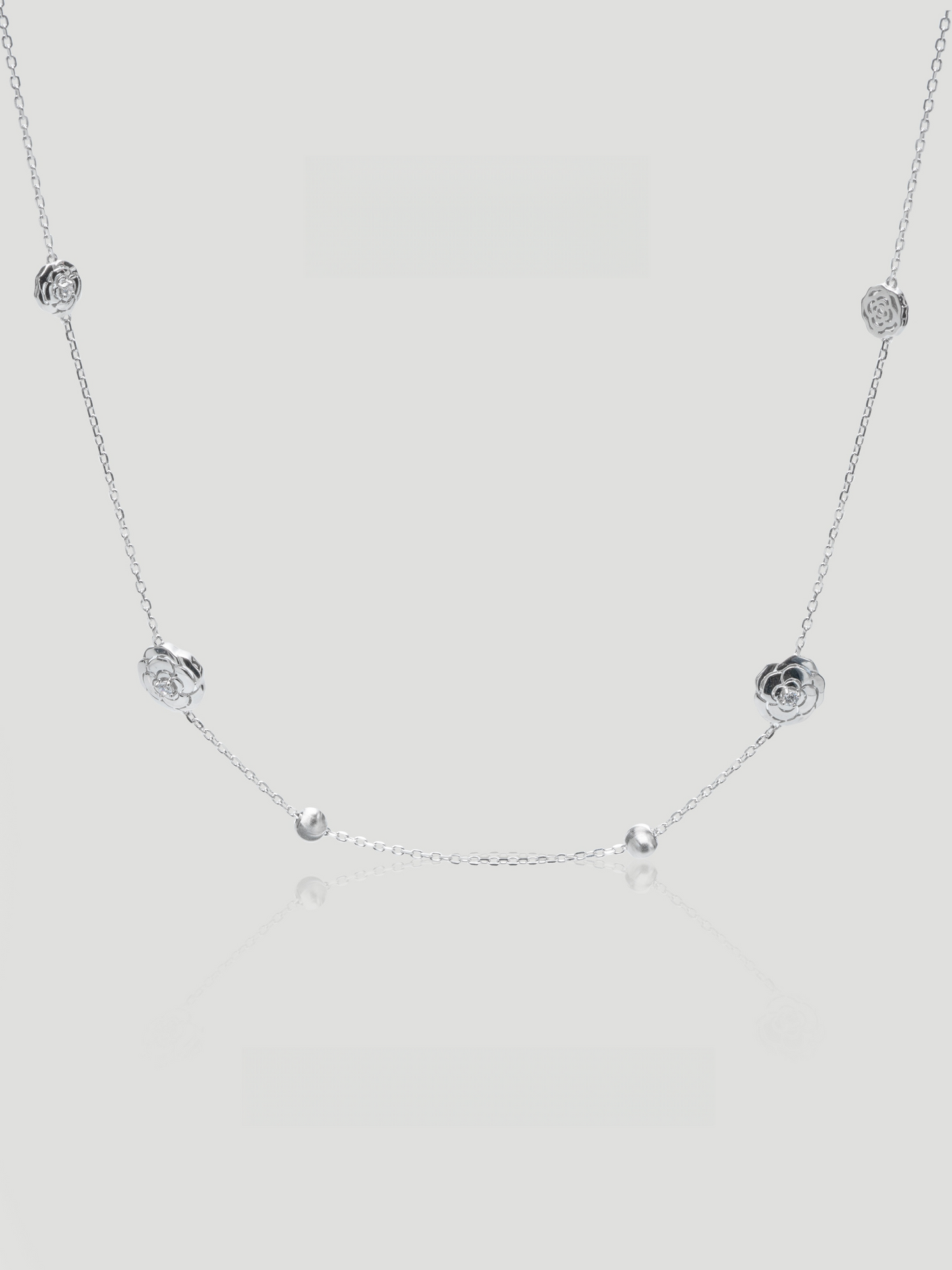 CARV. silver rose station necklace with floral bead stations, fine chain and polished round accents