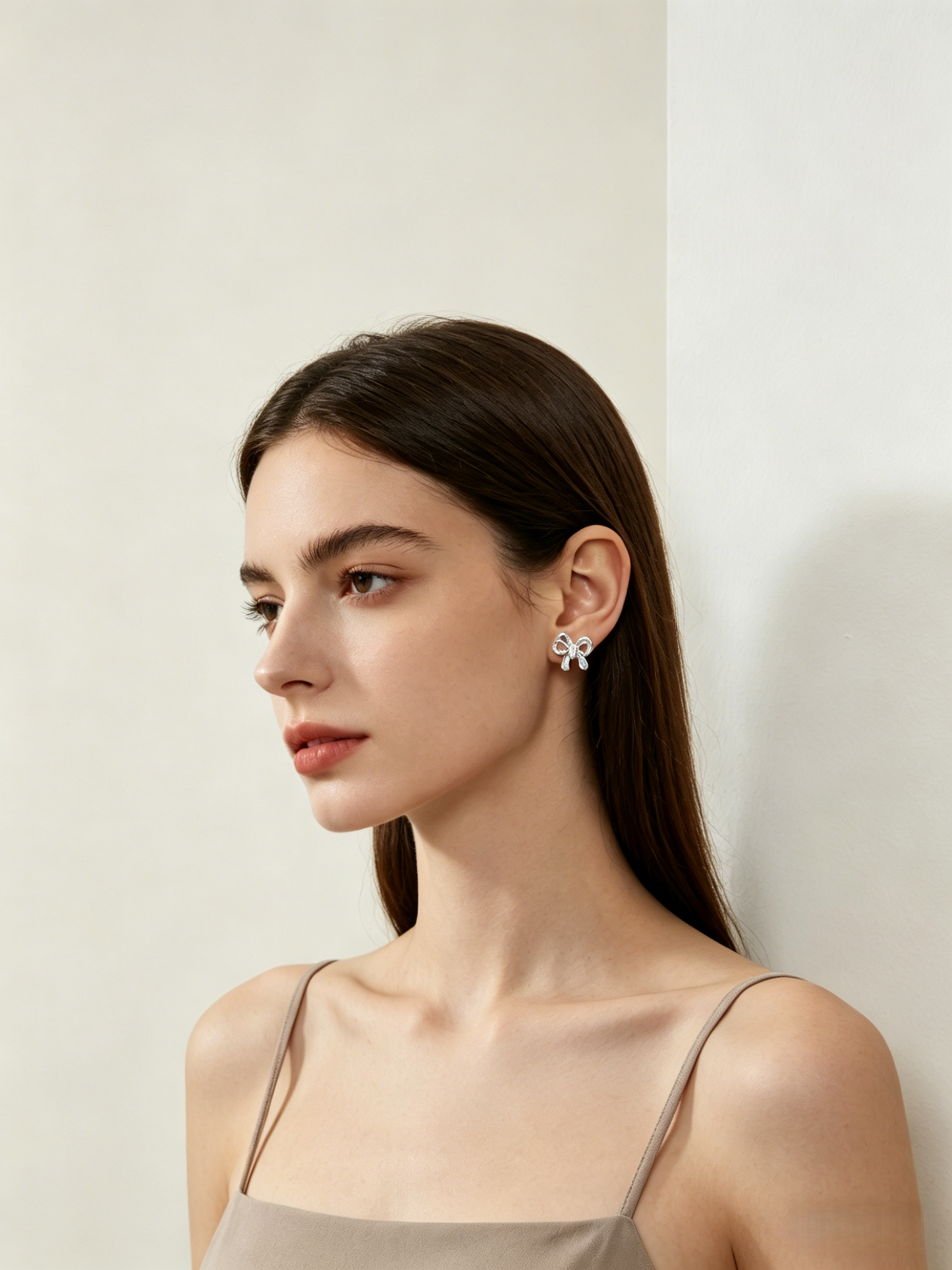 CARV. silver bow stud earrings worn on ear with sculptural ribbon shape and pavé detail