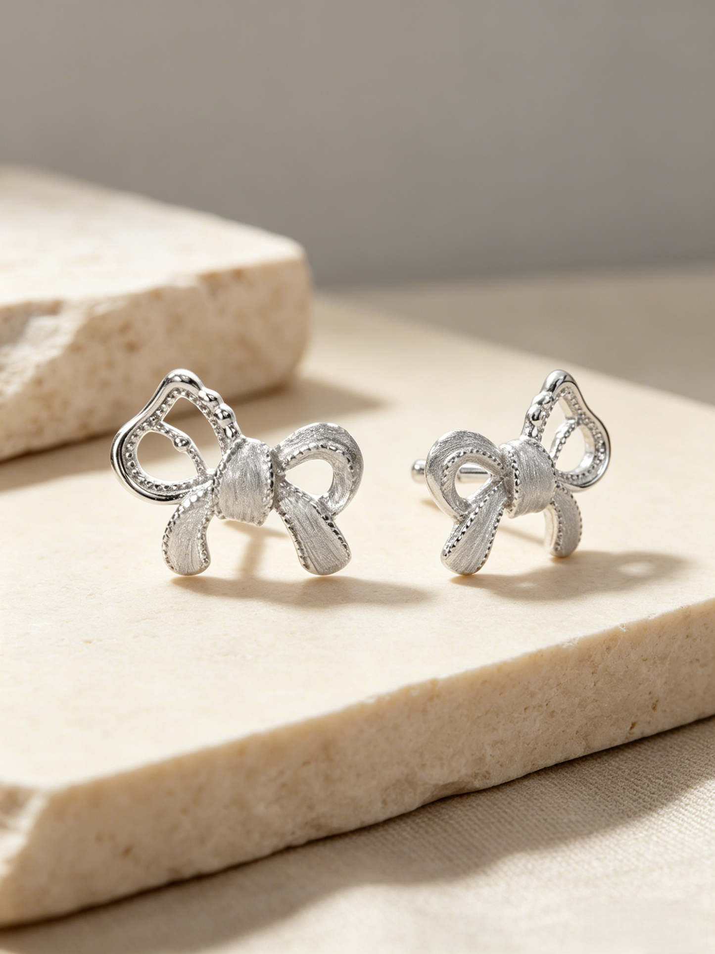 CARV. silver bow stud earrings with sculptural ribbon shape, pavé detail and post back design