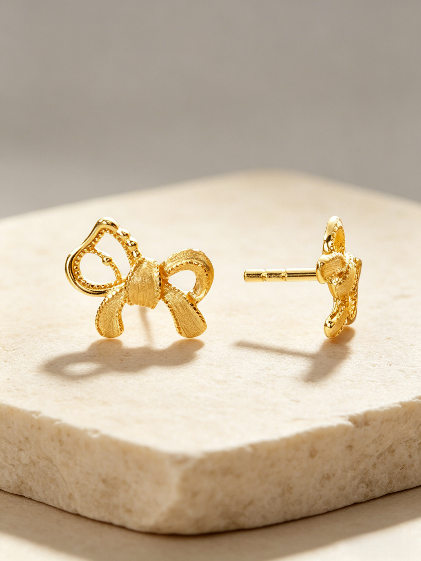 CARV. gold bow stud earrings with sculptural ribbon shape, pavé detail and post back design