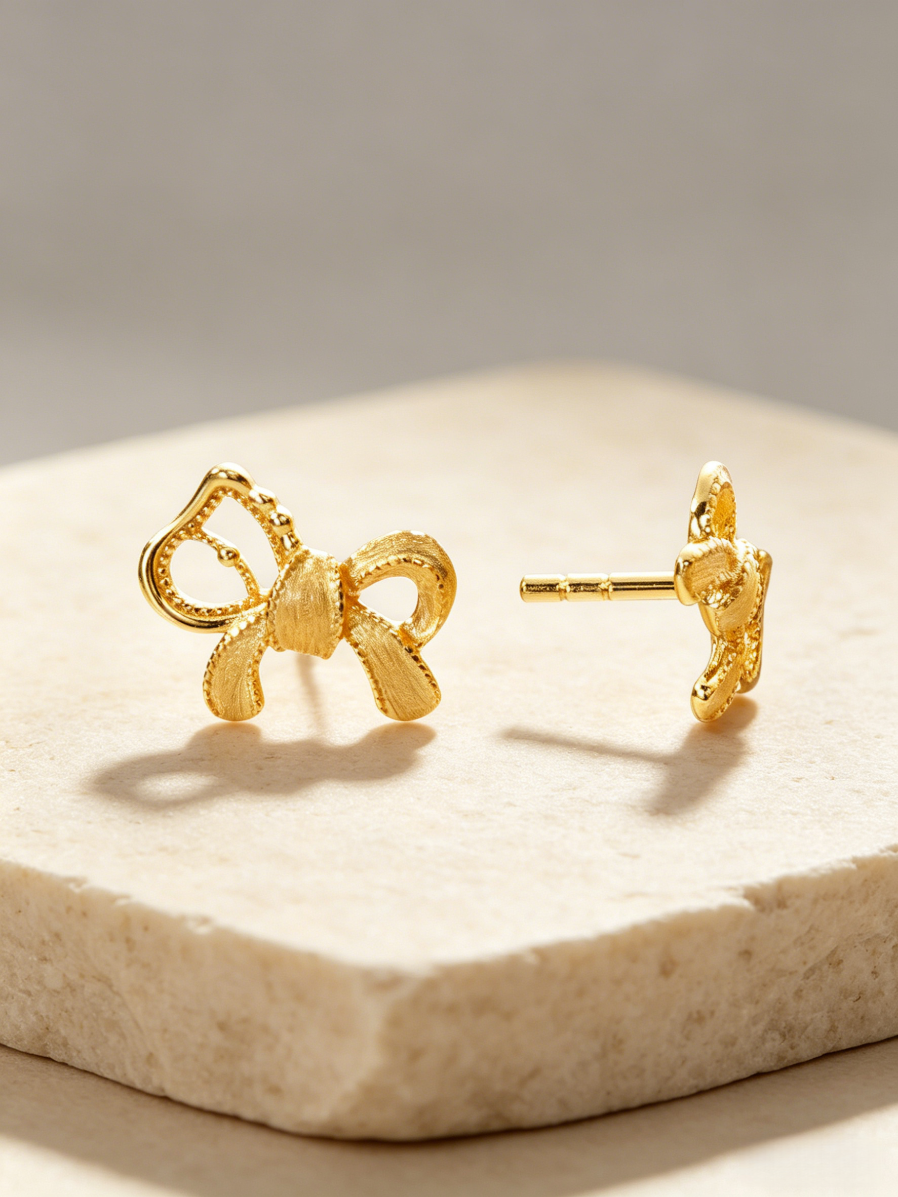 CARV. gold bow stud earrings with sculptural ribbon shape, pavé detail and post back design