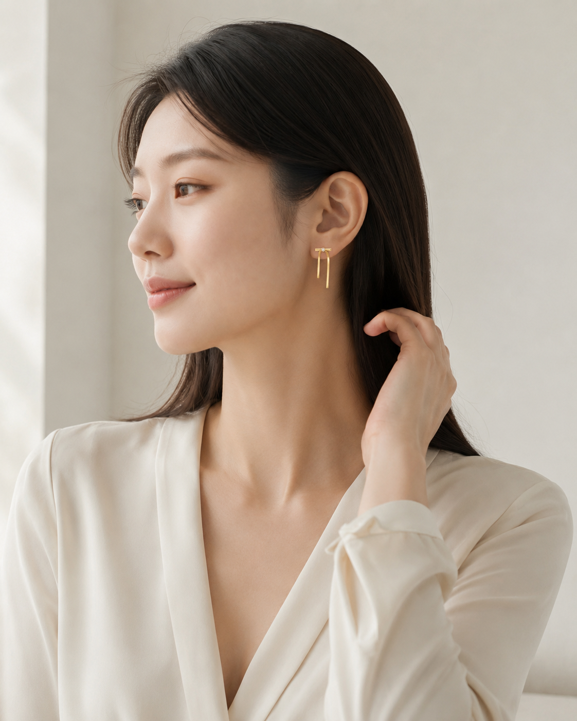 CARV. gold bar drop earrings shown on ear in portrait view with crystal stud detail