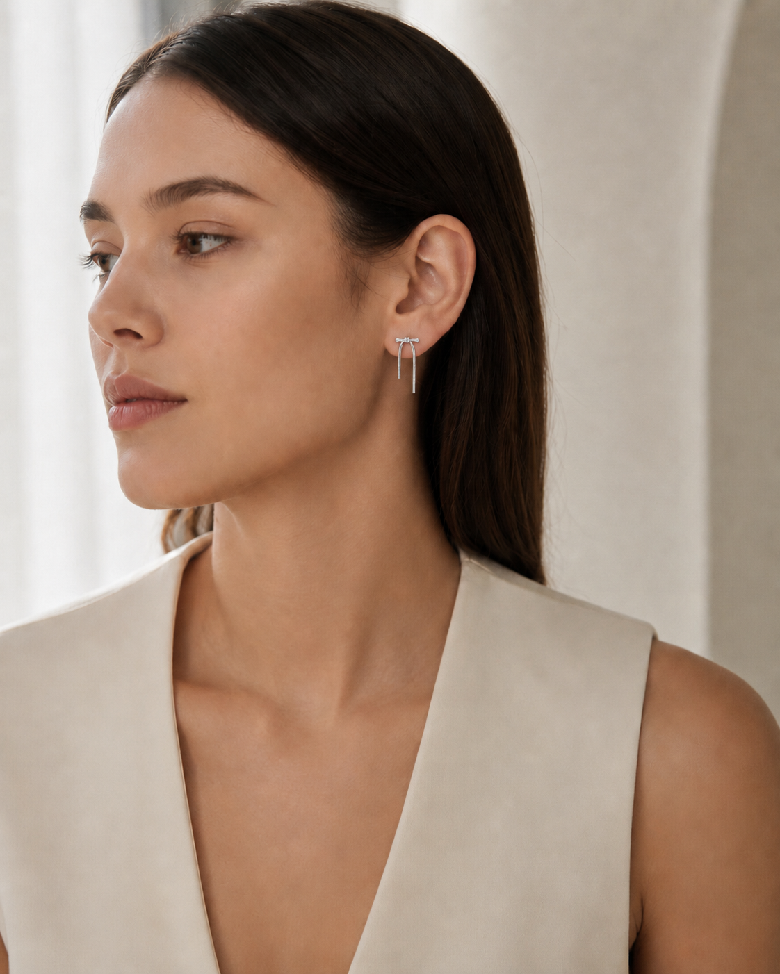 CARV. silver bar drop earrings shown on ear in portrait view with crystal stud detail