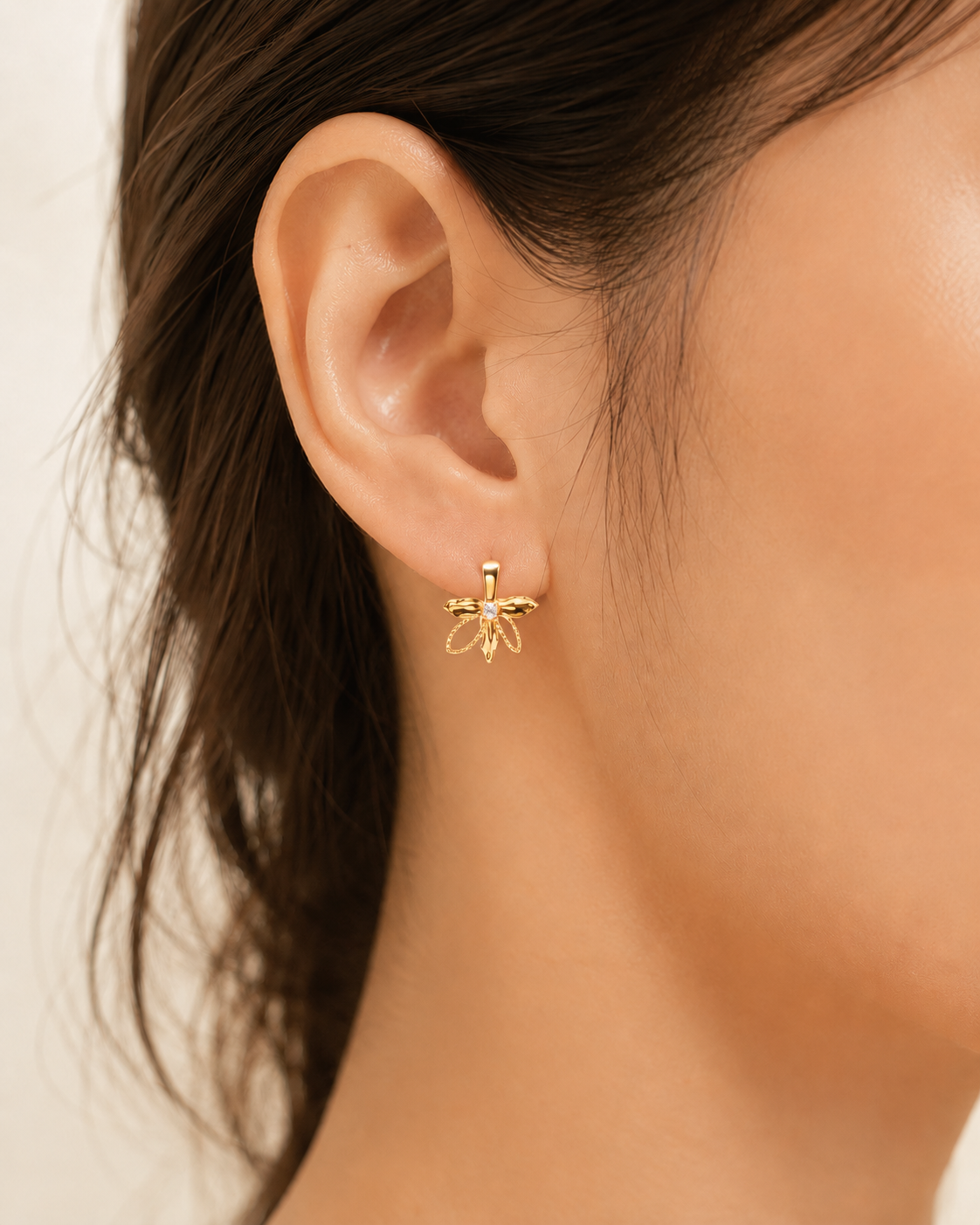 CARV. gold bow hoop earrings with pavé crystal detail worn on ear