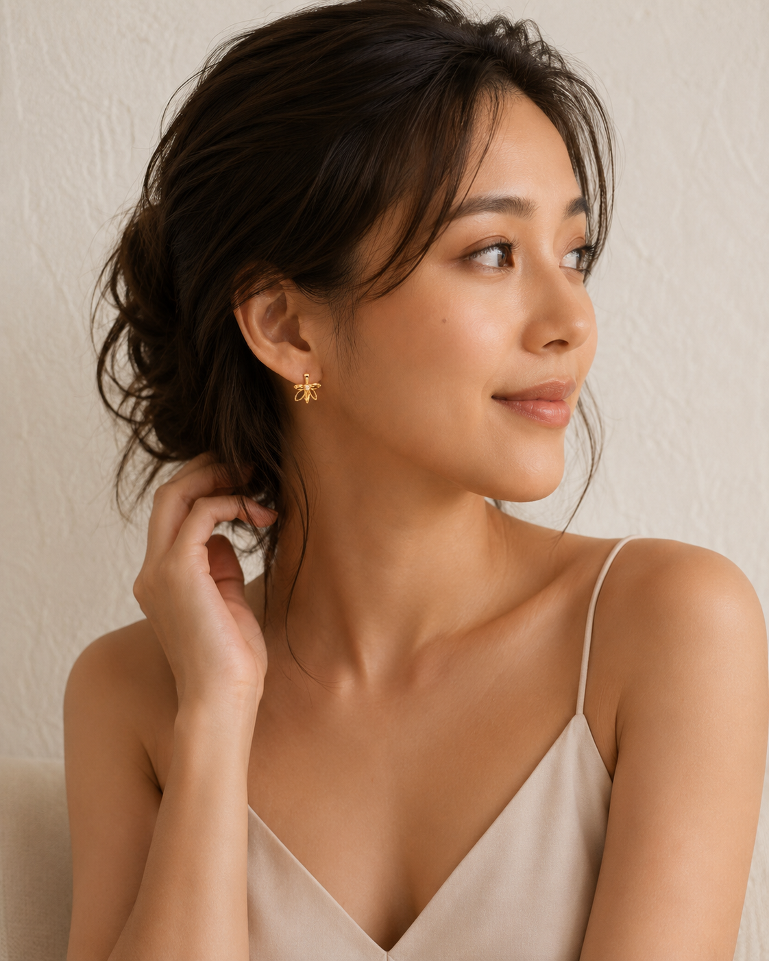 CARV. gold bow hoop earrings with sculptural bow shape worn on ear