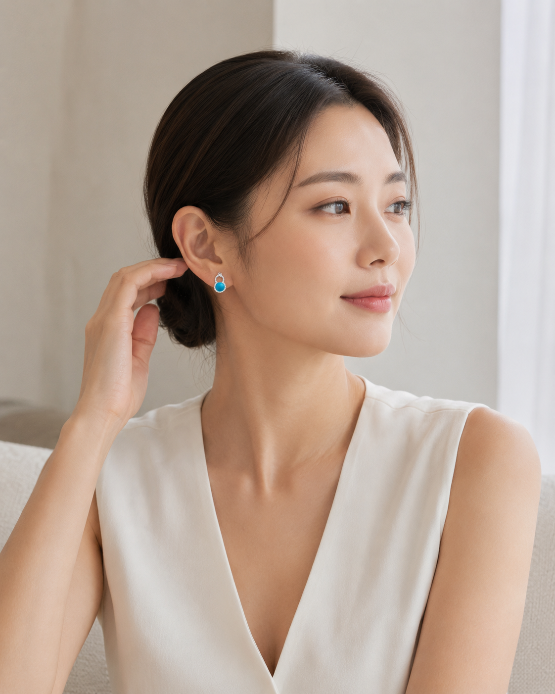 CARV. silver turquoise halo stud earrings shown on ear in portrait view with bright blue stone