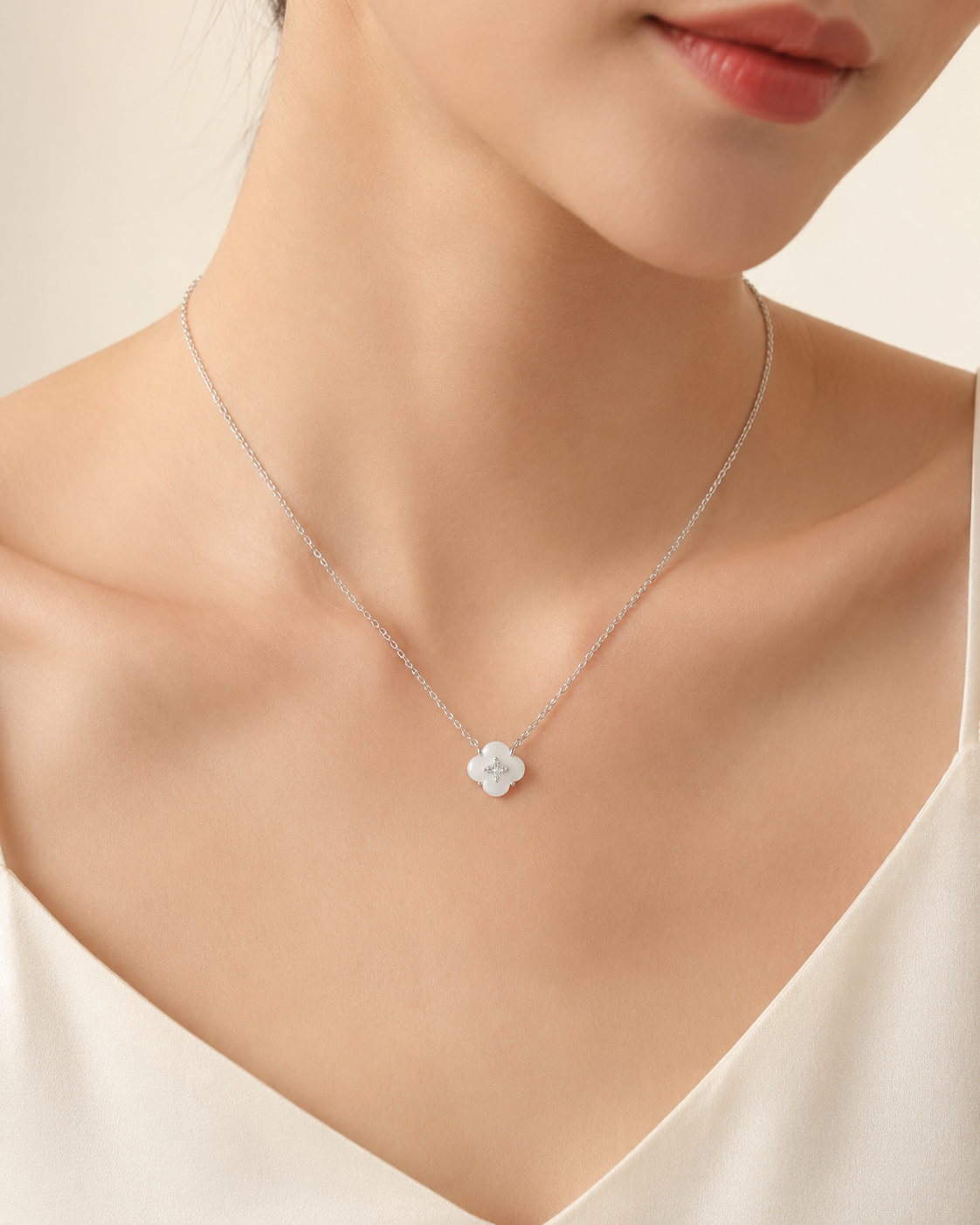 CARV. silver mother-of-pearl flower necklace worn on neck with white floral pendant and crystal centre