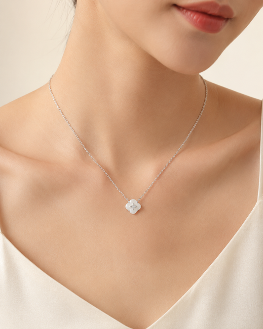 CARV. silver mother-of-pearl flower necklace worn on neck with white floral pendant and crystal centre