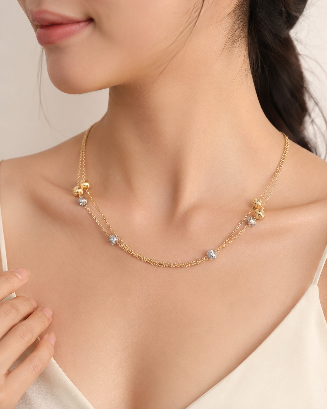 CARV. gold layered bead necklace with silver bead accents worn at collarbone