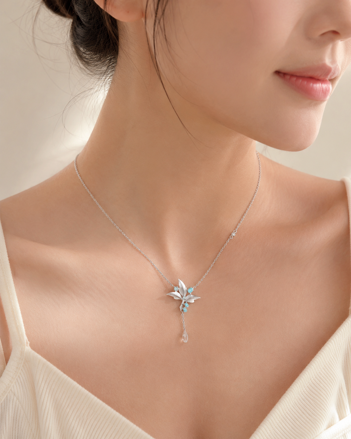 CARV. silver lily pendant necklace with turquoise accent worn at collarbone in close-up view