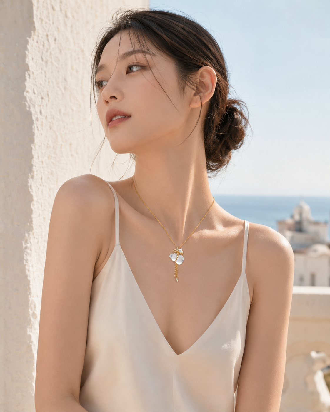 CARV. gold pendant necklace with white crystal charm and tassel detail worn at collarbone