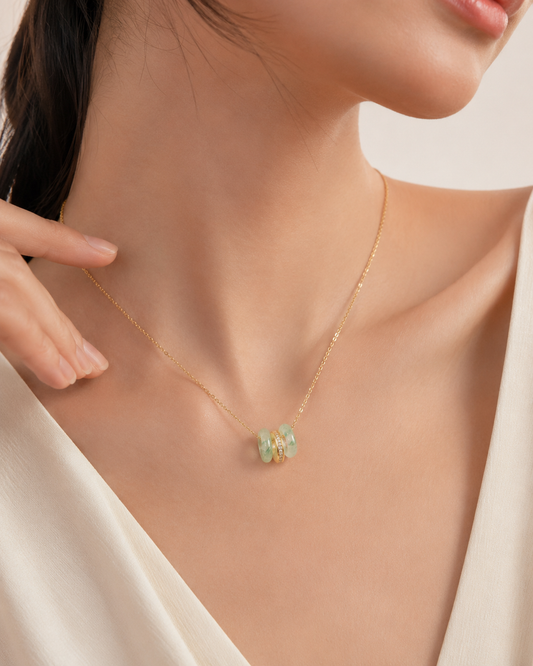 CARV. gold green stone orbit pendant necklace worn at collarbone with triple hoop pendant