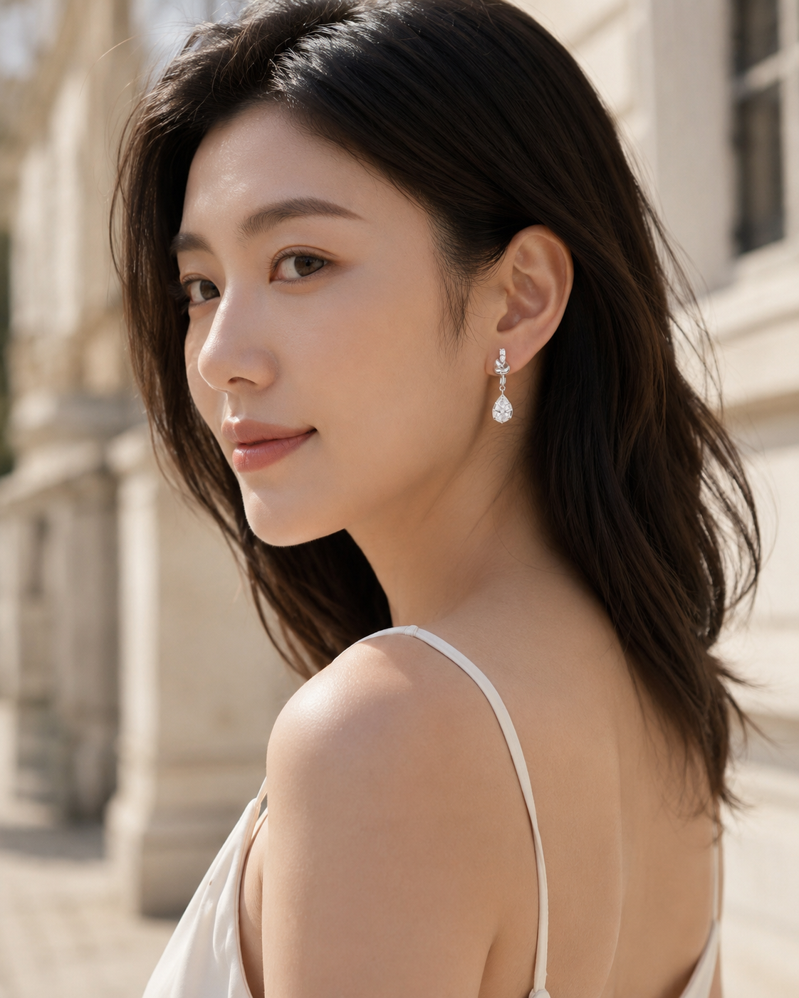 CARV. silver bow knot drop earrings worn on ear with delicate drop silhouette and clear stones