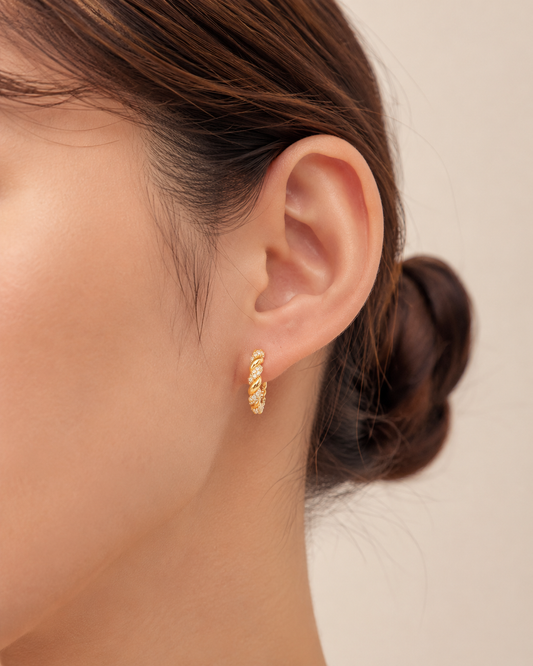 CARV. gold twisted pavé hoop earrings worn on ear with rope twist detail