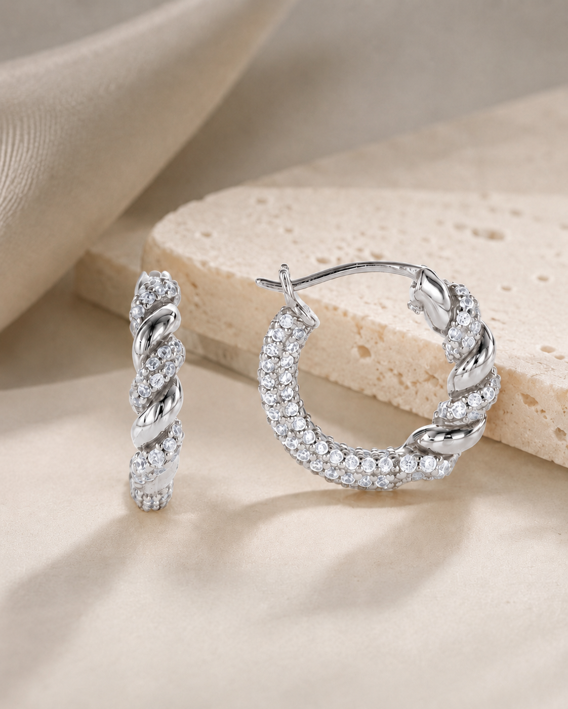 CARV. silver twisted pavé hoop earrings with rope twist detail on product display