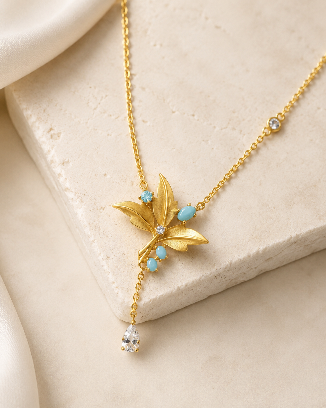 CARV. gold lily pendant necklace with turquoise accent, layered petals and tassel drop detail