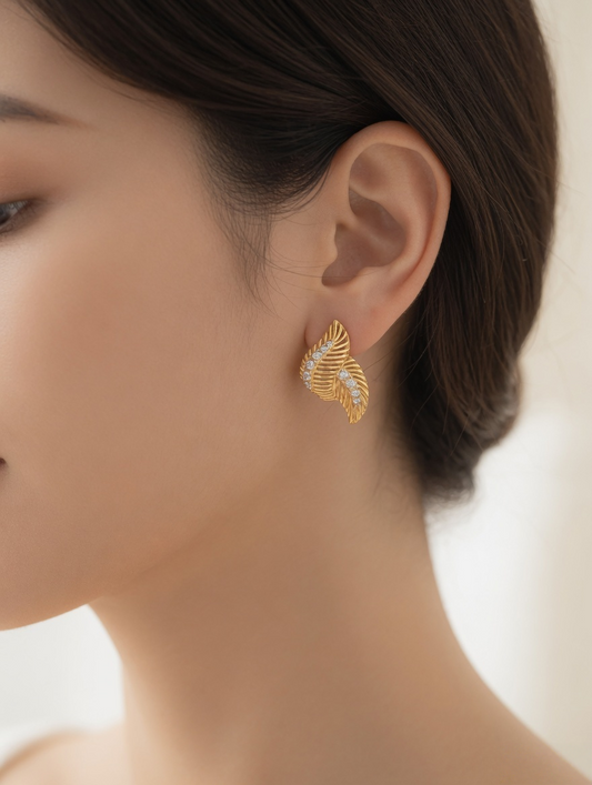 CARV. gold leaf pavé stud earrings worn on ear close-up