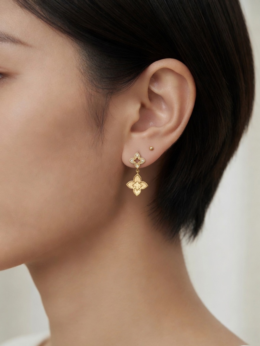 CARV. gold clover drop earrings worn on ear close-up