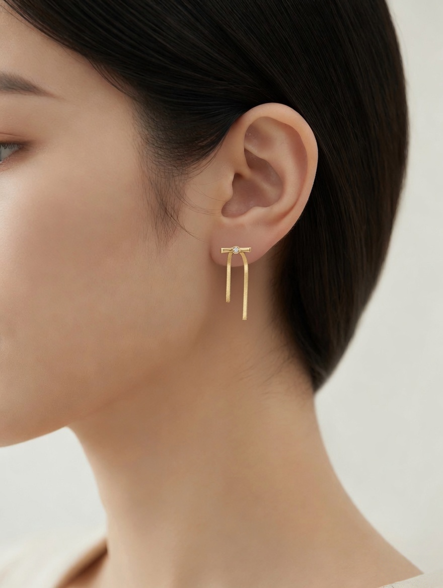CARV. gold bar drop earrings worn on ear with crystal stud and slim vertical drop detail