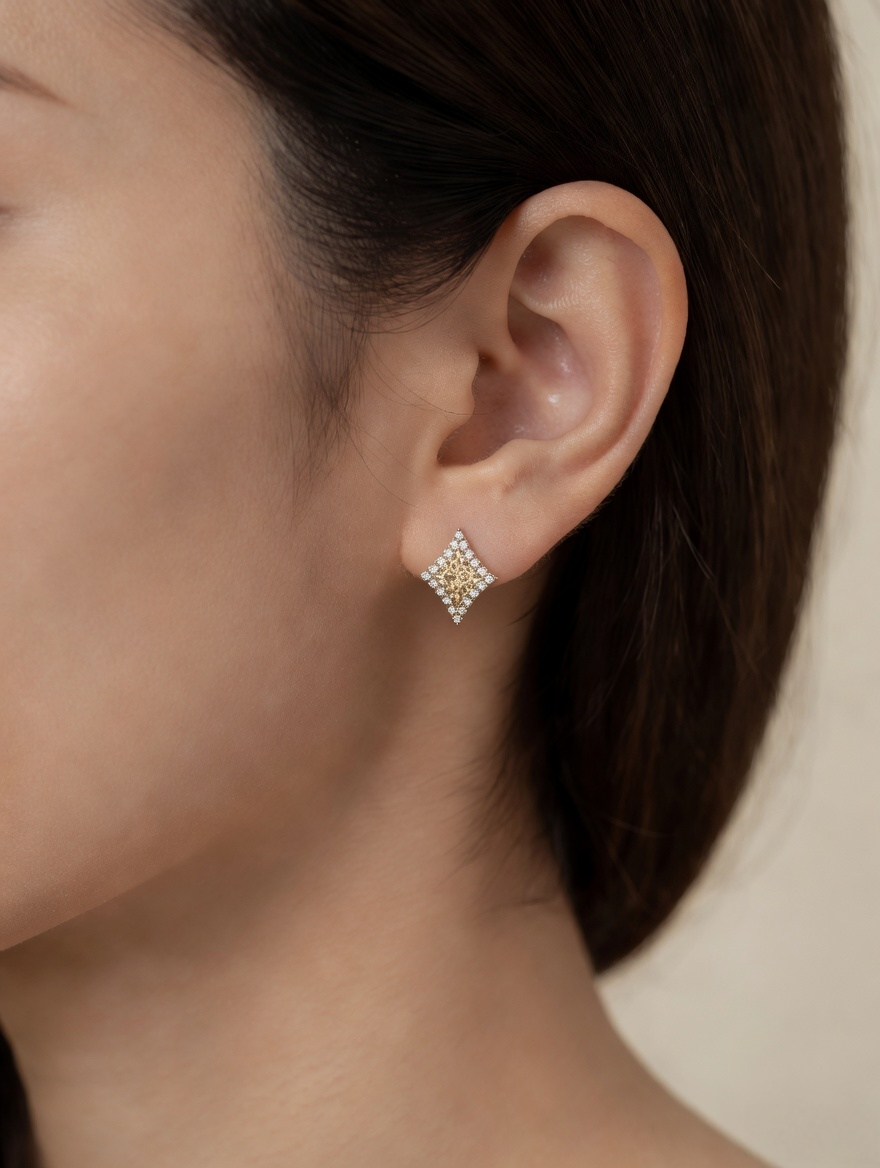 CARV. gold diamond lattice stud earrings with pavé border worn on ear