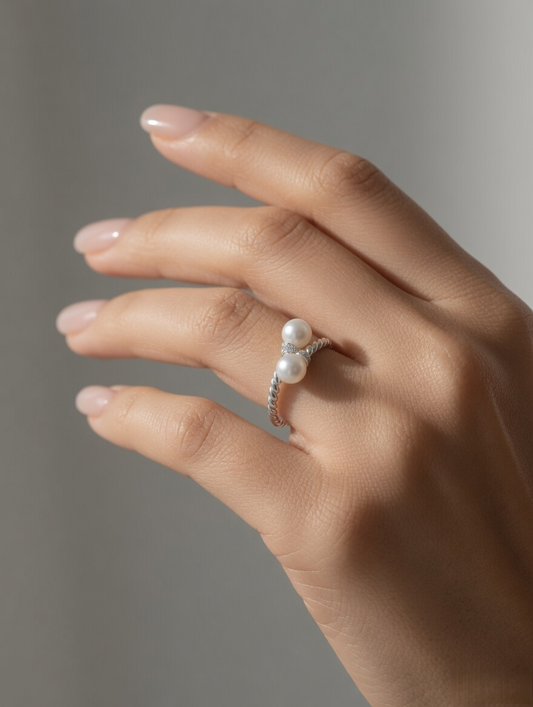 CARV. silver pearl twist ring worn on hand with double pearl detail and twisted band design